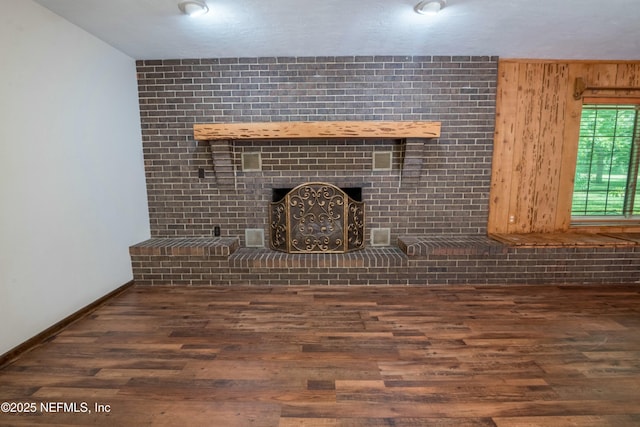 unfurnished living room featuring wood finished floors and baseboards