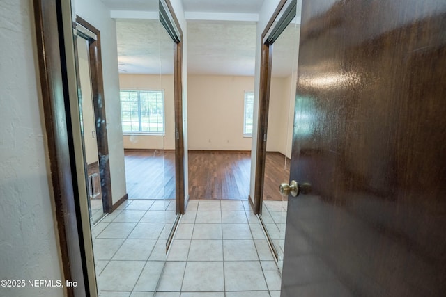 hall with light tile patterned floors and baseboards