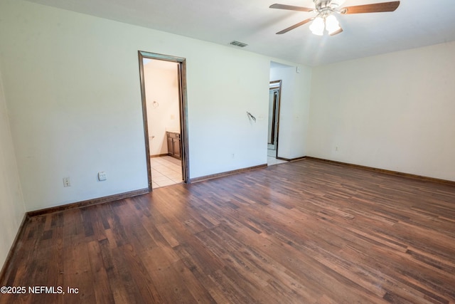 unfurnished room with wood finished floors, visible vents, a ceiling fan, and baseboards