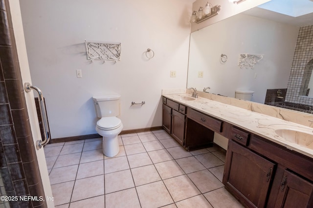 full bathroom with toilet, a skylight, a sink, and tile patterned floors