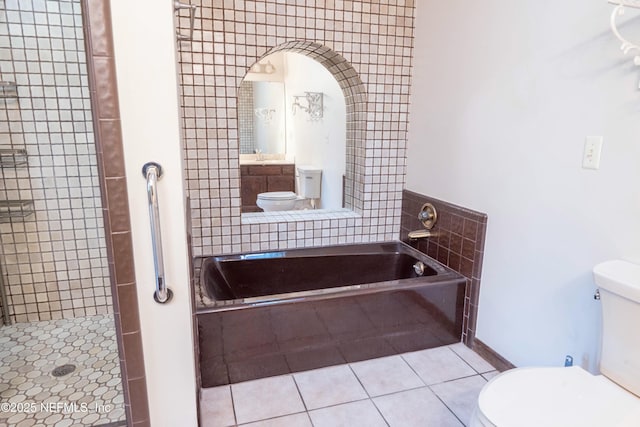bathroom featuring a shower stall, toilet, tile patterned flooring, and a garden tub