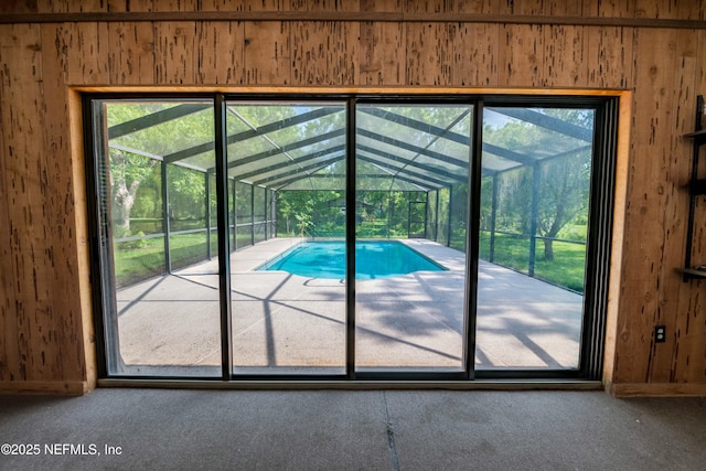 entryway featuring wooden walls, carpet flooring, and a sunroom