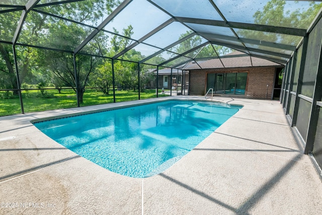 outdoor pool with glass enclosure and a patio area
