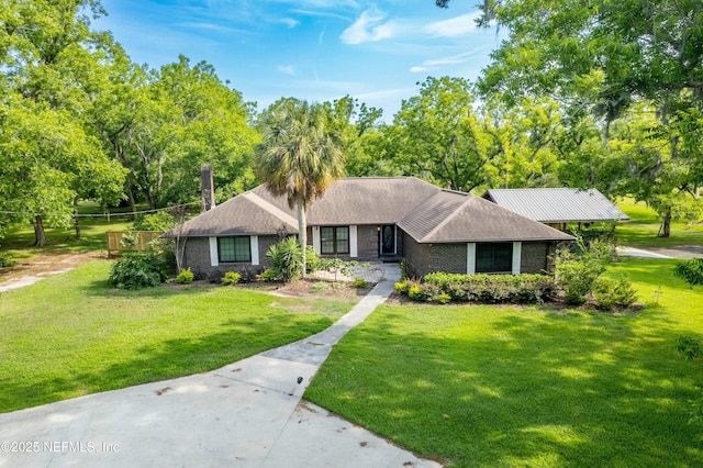 ranch-style house with a front yard and brick siding