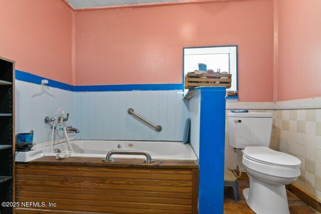 670 Hillsborough Ave, Florahome, FL 32140 - full bathroom featuring tile walls, a wainscoted wall, toilet, and a garden tub