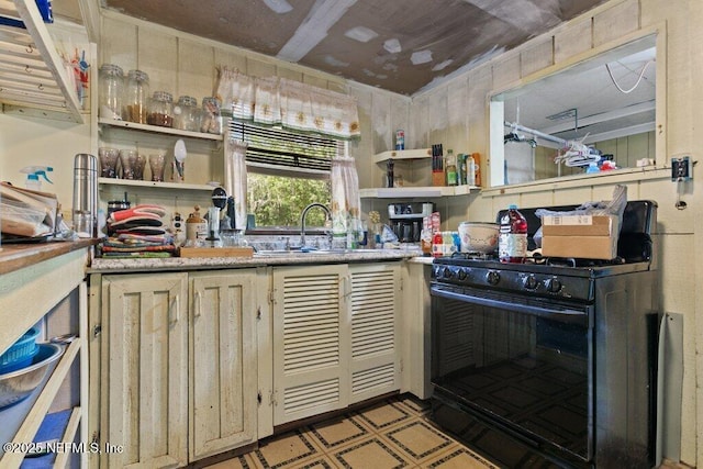 670 Hillsborough Ave, Florahome, FL 32140 - kitchen with black range with gas stovetop, open shelves, light floors, and a sink