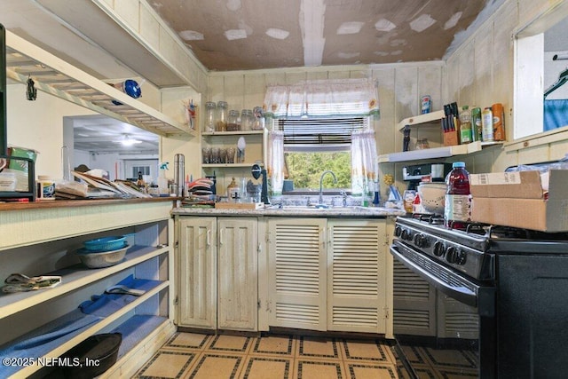 670 Hillsborough Ave, Florahome, FL 32140 - kitchen with light floors, cream cabinets, open shelves, black gas stove, and a sink