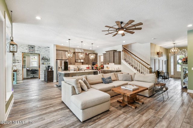 225 Shinnecock Dr, Saint Johns, FL 32259 - living area featuring recessed lighting, stairway, light wood finished floors, a textured ceiling, and ceiling fan with notable chandelier