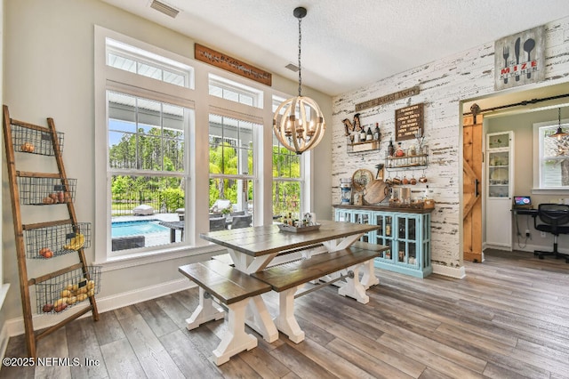 225 Shinnecock Dr, Saint Johns, FL 32259 - dining area featuring a barn door, an inviting chandelier, wood finished floors, visible vents, and baseboards