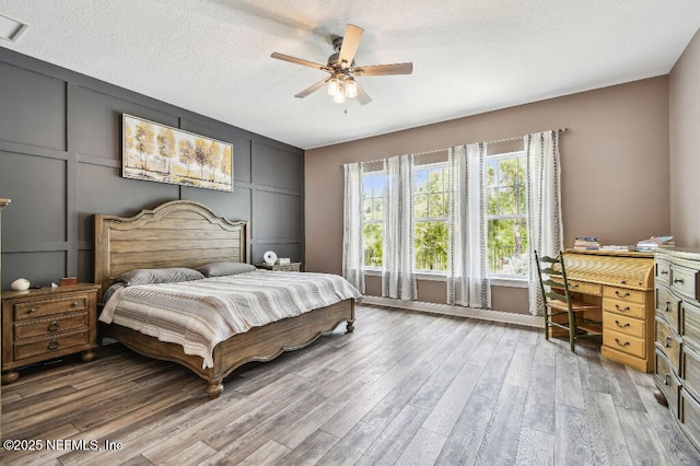 225 Shinnecock Dr, Saint Johns, FL 32259 - bedroom with a decorative wall, wood finished floors, a textured ceiling, and ceiling fan
