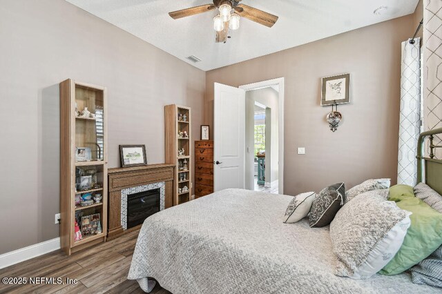 225 Shinnecock Dr, Saint Johns, FL 32259 - bedroom featuring wood finished floors, a glass covered fireplace, ceiling fan, baseboards, and visible vents