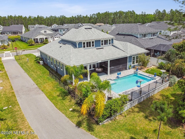 225 Shinnecock Dr, Saint Johns, FL 32259 - rear view of house with a fenced in pool, a shingled roof, a fenced backyard, a residential view, and a sunroom