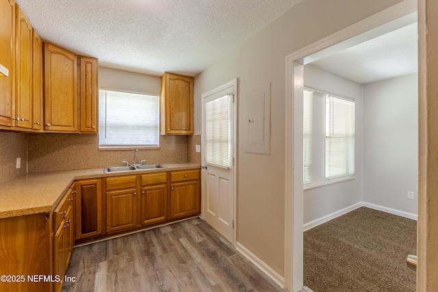 8344 Delaware Ave, Jacksonville, FL 32208 - kitchen featuring brown cabinets, light countertops, a sink, decorative backsplash, and a textured ceiling