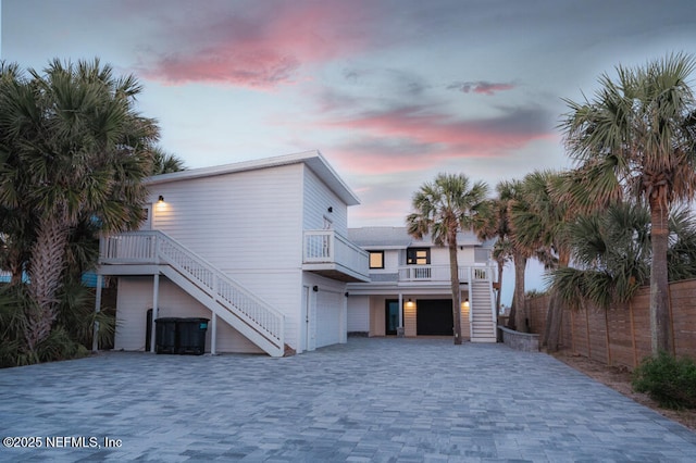 2818 Coastal Hwy, Saint Augustine, FL 32084 - back of property featuring fence, an attached garage, decorative driveway, and stairway