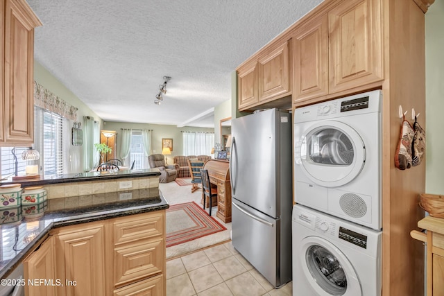 3434 Blanding Blvd Unit 214, Jacksonville, FL 32210 - laundry room with a textured ceiling, light tile patterned flooring, stacked washer / drying machine, track lighting, and laundry area