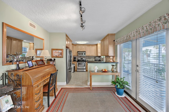 3434 Blanding Blvd Unit 214, Jacksonville, FL 32210 - kitchen with stainless steel appliances, track lighting, dark countertops, visible vents, and decorative backsplash