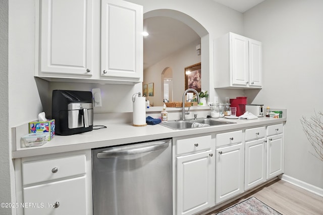 kitchen with a sink, white cabinetry, dishwasher, and light countertops