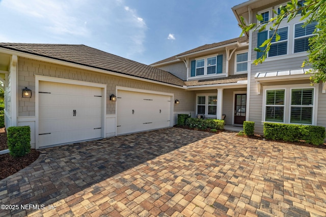 traditional-style home with an attached garage and decorative driveway