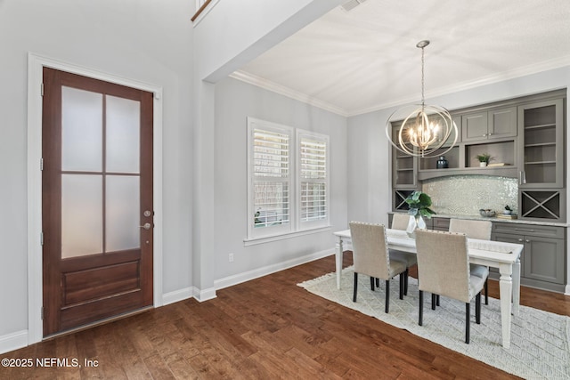 dining space featuring baseboards, ornamental molding, an inviting chandelier, and dark wood-style floors