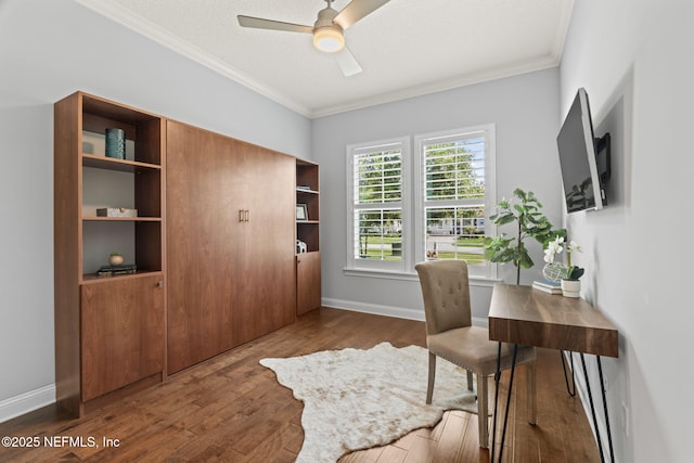 home office featuring a ceiling fan, ornamental molding, baseboards, and wood finished floors