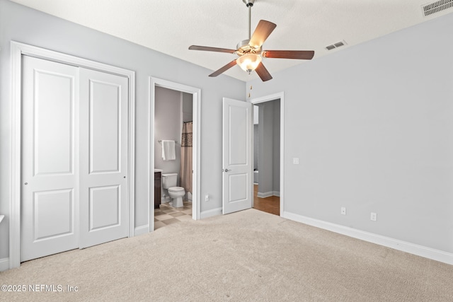 unfurnished bedroom with carpet flooring, a closet, visible vents, and baseboards