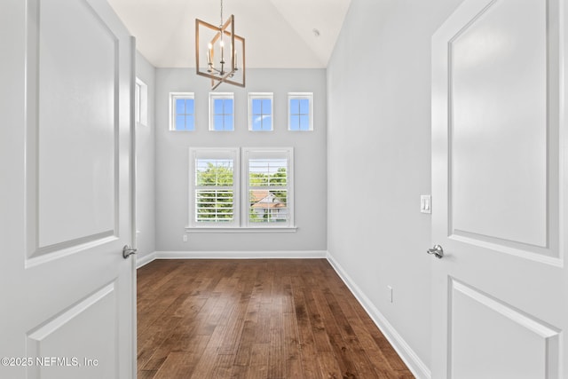 interior space featuring an inviting chandelier, dark wood finished floors, baseboards, and high vaulted ceiling