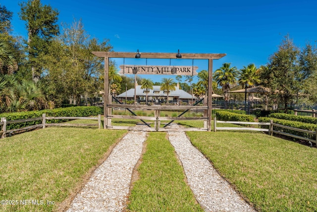 view of home's community with a yard and fence
