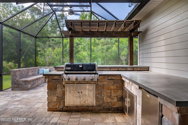 view of patio with exterior kitchen, a grill, and glass enclosure