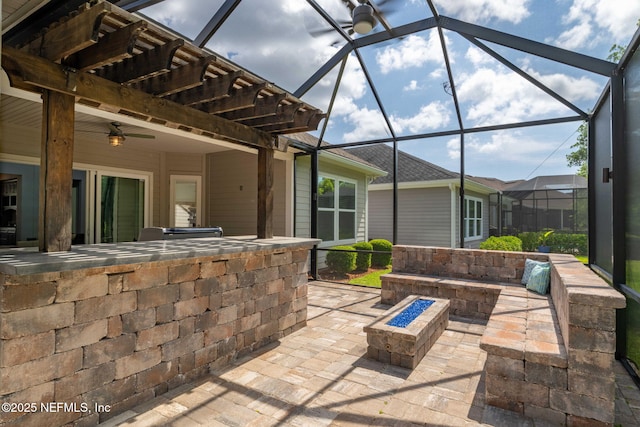 view of patio with an outdoor fire pit, a lanai, and a ceiling fan