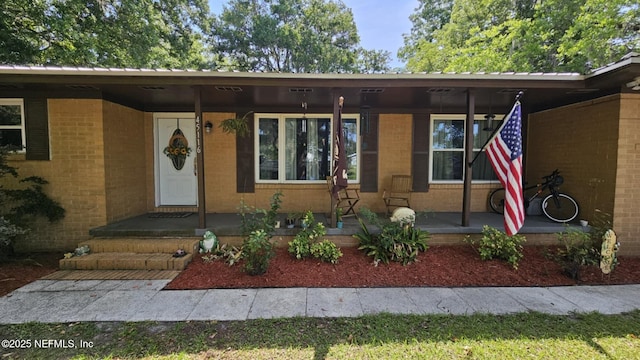 45116 Coquina Way, Callahan, FL 32011 - property entrance with a porch, brick siding, and metal roof