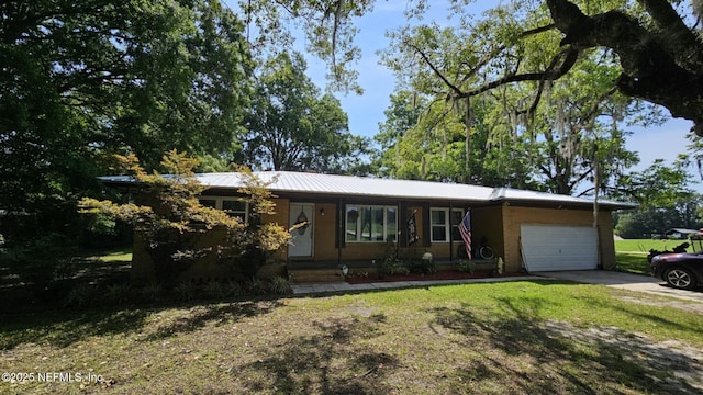 45116 Coquina Way, Callahan, FL 32011 - ranch-style house with an attached garage, concrete driveway, a front lawn, and metal roof