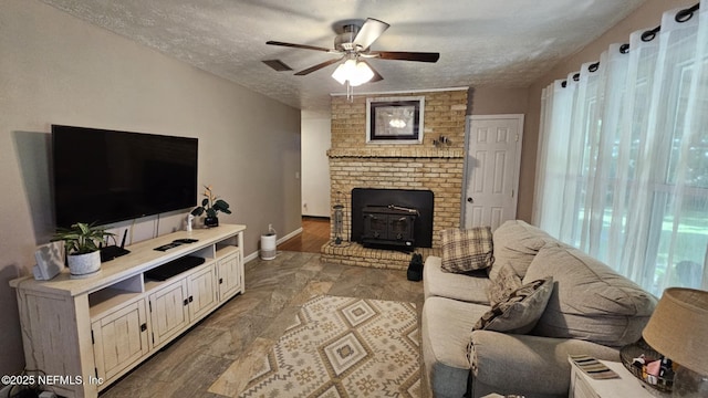 45116 Coquina Way, Callahan, FL 32011 - living room with a wood stove, ceiling fan, a textured ceiling, and baseboards