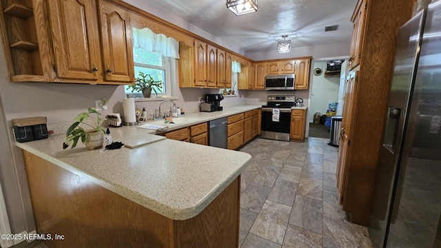 45116 Coquina Way, Callahan, FL 32011 - kitchen featuring appliances with stainless steel finishes, a sink, a peninsula, light countertops, and light stone finish flooring