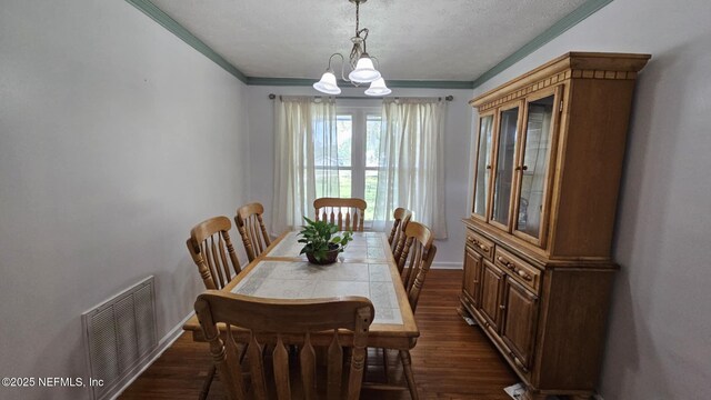 45116 Coquina Way, Callahan, FL 32011 - dining area featuring crown molding, dark wood-style floors, baseboards, a chandelier, and a textured ceiling