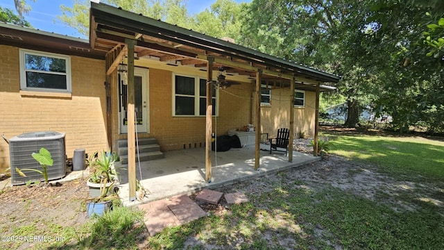 45116 Coquina Way, Callahan, FL 32011 - back of house featuring central AC unit, entry steps, a patio, brick siding, and a yard