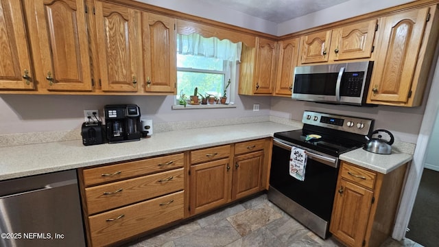 45116 Coquina Way, Callahan, FL 32011 - kitchen with stainless steel appliances, brown cabinetry, light countertops, and light stone finish floors