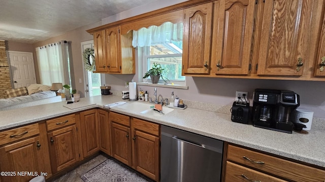 45116 Coquina Way, Callahan, FL 32011 - kitchen with stainless steel dishwasher, a sink, brown cabinetry, and light countertops
