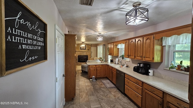 45116 Coquina Way, Callahan, FL 32011 - kitchen with dishwasher, light countertops, a sink, brown cabinets, and stone finish flooring