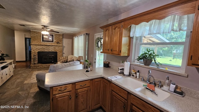 45116 Coquina Way, Callahan, FL 32011 - kitchen with light countertops, a peninsula, brown cabinets, a sink, and a textured ceiling