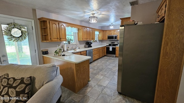 45116 Coquina Way, Callahan, FL 32011 - kitchen with appliances with stainless steel finishes, a peninsula, light stone finish flooring, light countertops, and open shelves