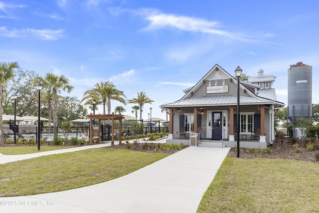 2793 Pointed Leaf Rd, Green Cove Springs, FL 32043 - view of front of home with fence, covered porch, a front yard, and metal roof