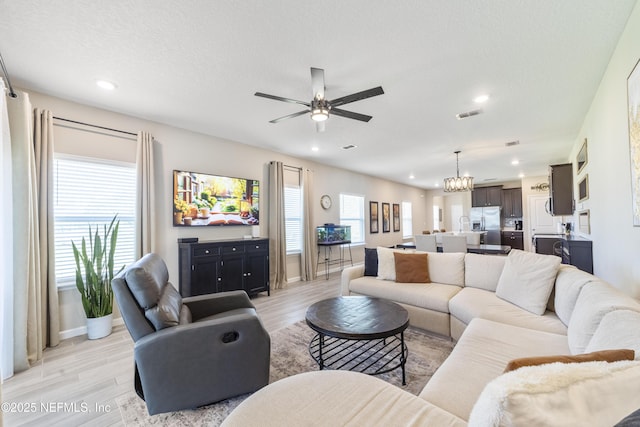 2793 Pointed Leaf Rd, Green Cove Springs, FL 32043 - living room with recessed lighting, light wood-type flooring, visible vents, and ceiling fan with notable chandelier