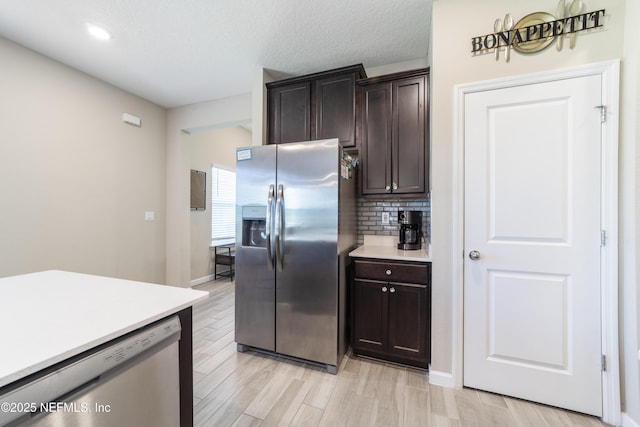 2793 Pointed Leaf Rd, Green Cove Springs, FL 32043 - kitchen with dark brown cabinets, decorative backsplash, light wood-style floors, light countertops, and appliances with stainless steel finishes
