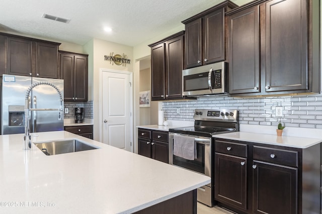 2793 Pointed Leaf Rd, Green Cove Springs, FL 32043 - kitchen with a sink, tasteful backsplash, visible vents, light countertops, and appliances with stainless steel finishes