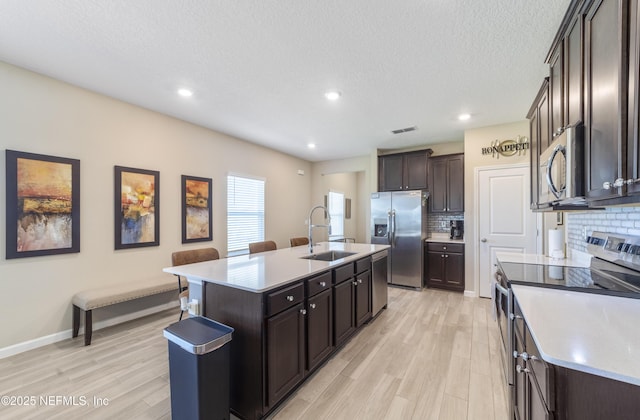 2793 Pointed Leaf Rd, Green Cove Springs, FL 32043 - kitchen featuring light wood finished floors, stainless steel appliances, a sink, and tasteful backsplash
