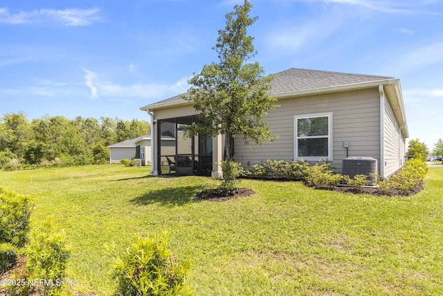 2793 Pointed Leaf Rd, Green Cove Springs, FL 32043 - rear view of house with a shingled roof, a sunroom, a yard, and central AC