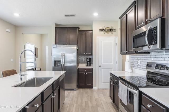 2793 Pointed Leaf Rd, Green Cove Springs, FL 32043 - kitchen with visible vents, dark brown cabinetry, stainless steel appliances, and a sink