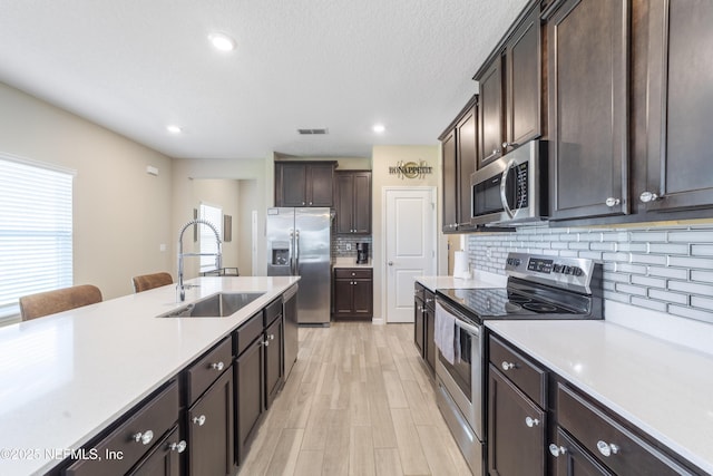 2793 Pointed Leaf Rd, Green Cove Springs, FL 32043 - kitchen featuring dark brown cabinets, a sink, stainless steel appliances, light countertops, and visible vents