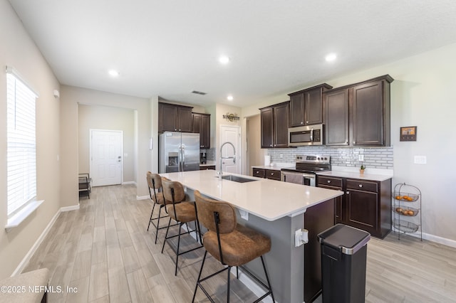 2793 Pointed Leaf Rd, Green Cove Springs, FL 32043 - kitchen featuring light wood finished floors, a kitchen breakfast bar, a sink, and appliances with stainless steel finishes