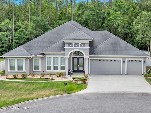 view of front of property with a front lawn, stucco siding, french doors, concrete driveway, and an attached garage
